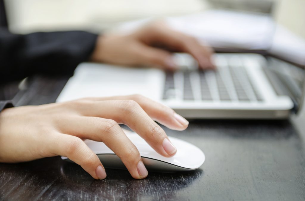 Woman hand on mouse and other one on keyboard