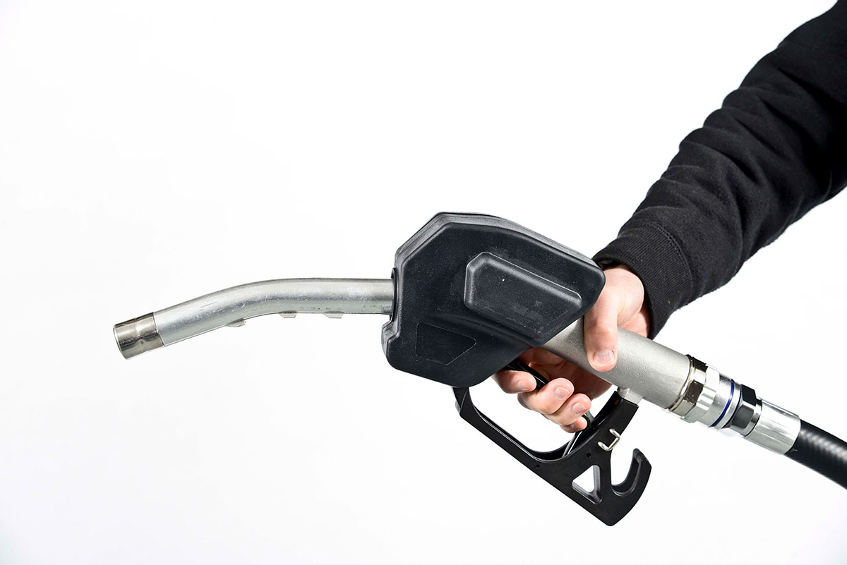 person holding a black fuel filler pump nozzle on a white background