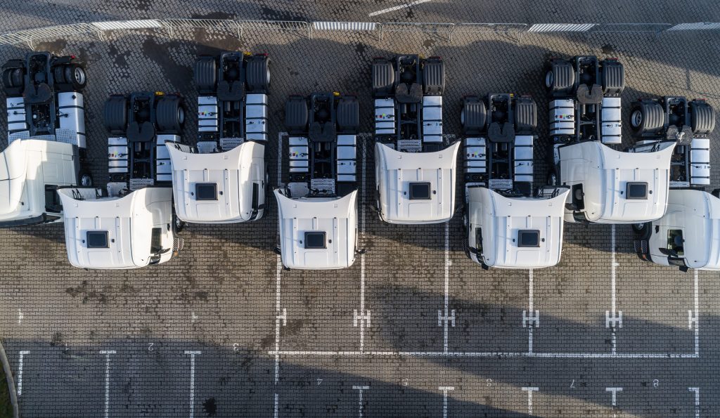 Aerial drone view of parked white trucks. Road transport