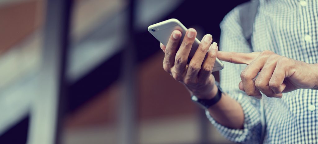 close up traveler backpacker man hand holding smartphone for checking flight online or search information on browser website about plan trip at destination , lifestyle concept