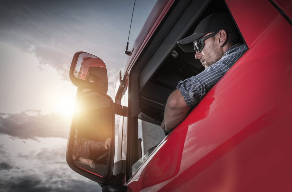 Red Semi Truck. Caucasian Truck Driver Preparing For the Next Destination.