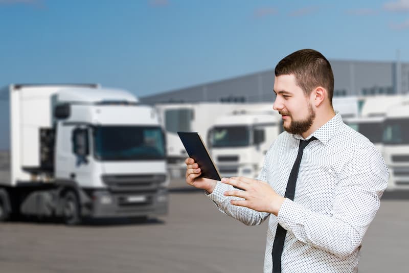 manager with tablet and lorry
