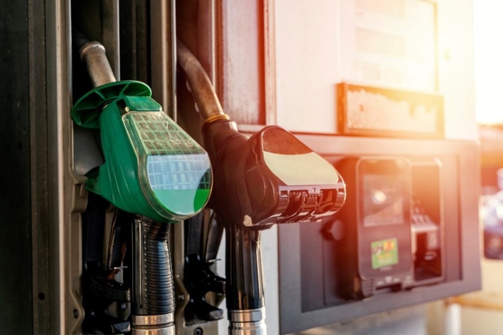 An image of a fuel pump. One green capped pump and one black capped pump. 