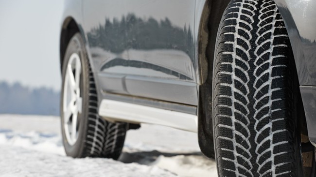 Close-up of a car's side with tyre treads